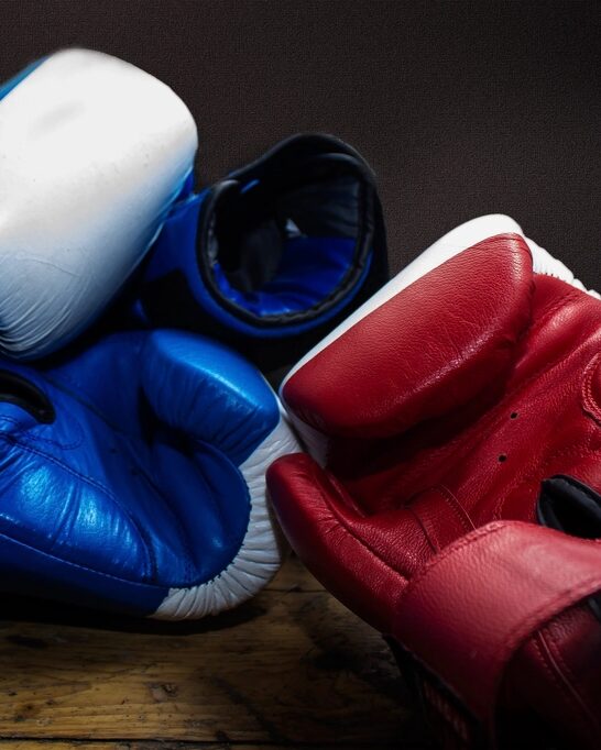 Guantes de boxeo rojos y azules sobre una banca de madera