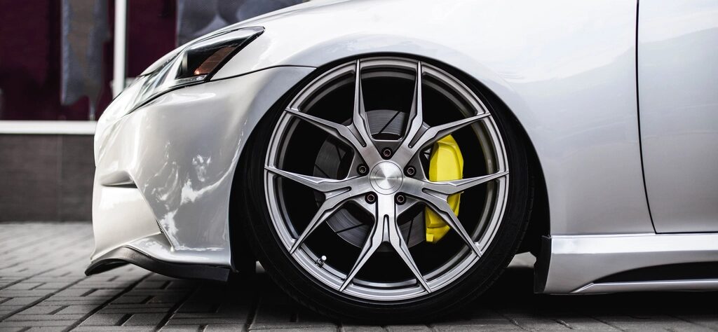 Rueda delantera de un carro blanco con el disco y el caliper de freno a la vista